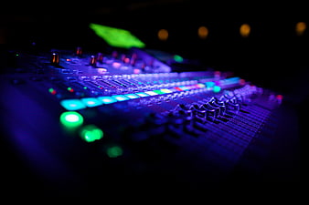 Close-up of illuminated audio mixing console with glowing buttons