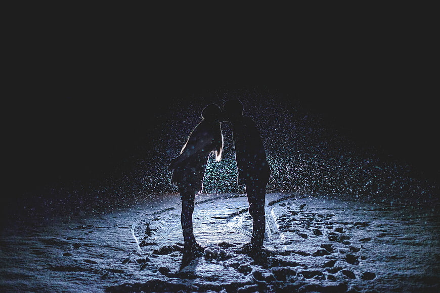 Silhouette of Couple Kissing in Snowy Night