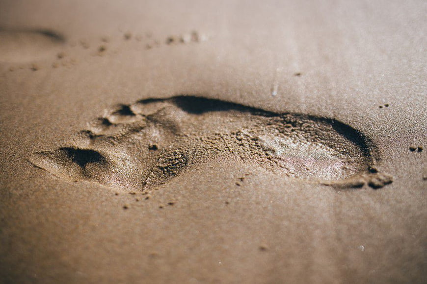 Close-up of single footprint in wet sand texture