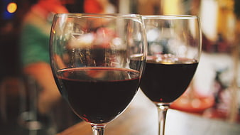Two glasses of red wine on a table at a restaurant