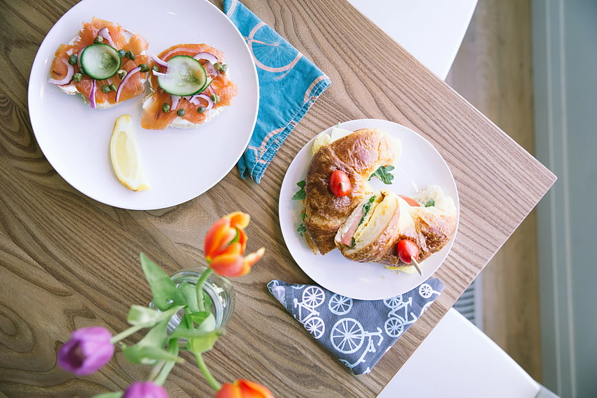 Overhead view of smoked salmon and croissant breakfast on wooden table