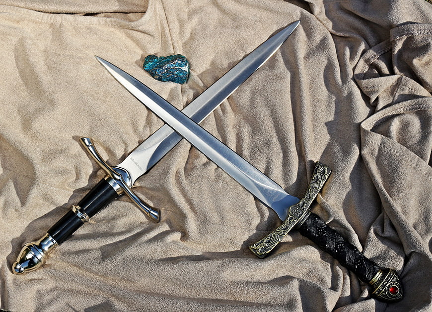 Crossed ornamental daggers and blue stone on beige fabric