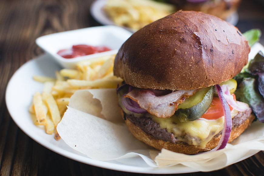 Delicious Bacon Cheeseburger with Fries on Wooden Table