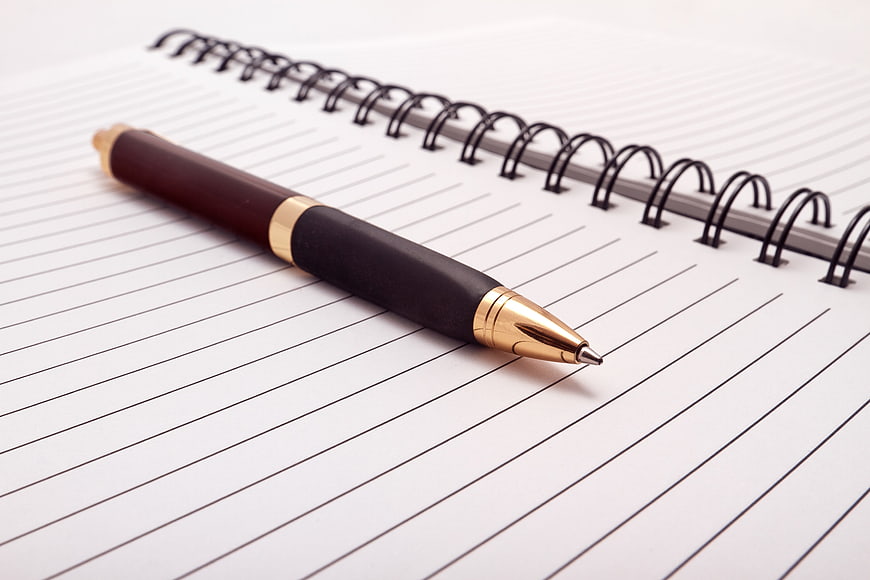 Gold and black pen on spiral notebook