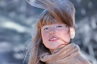 Portrait of young girl with windblown hair outdoors