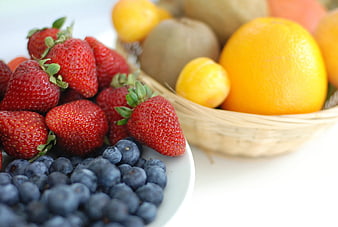 Fresh Strawberries, Blueberries, and Oranges in Baskets