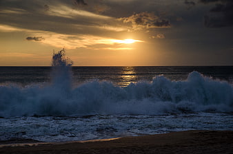 Dramatic Ocean Sunset with Crashing Waves and Golden Sky