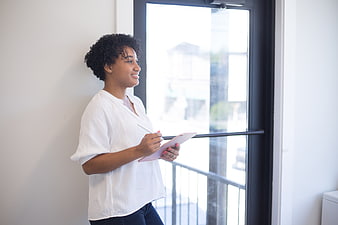 Confident Black Woman Using Tablet by Window