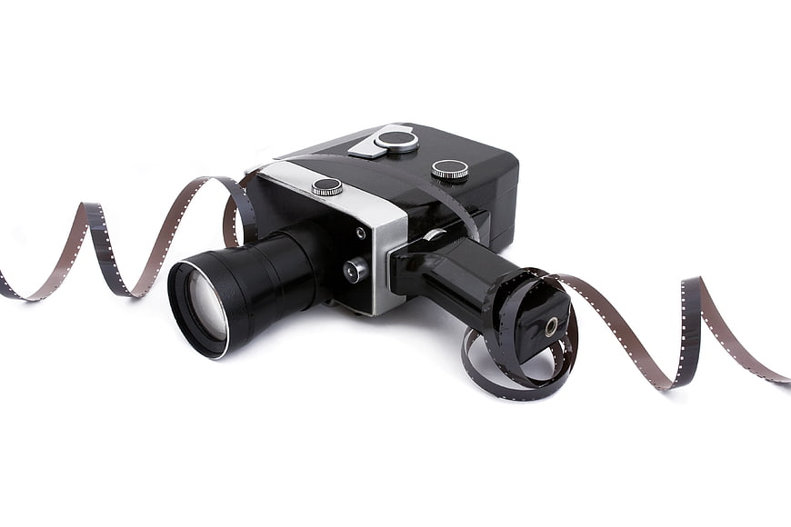 Vintage 8mm Film Camera with Filmstrip on White Background