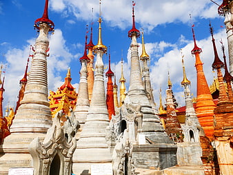 Colorful Buddhist Stupas in Myanmar Against Blue Sky