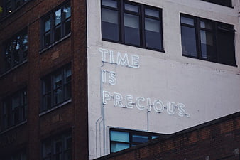 Time Is Precious Neon Sign on Urban Building Facade