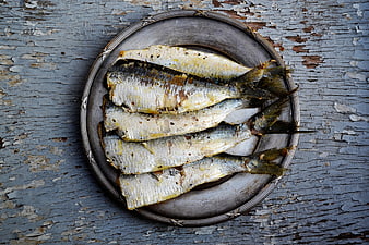 Grilled sardines on rustic metal plate
