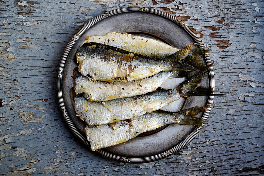 Grilled sardines on rustic metal plate