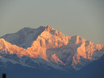 Snowy Mountain Peak Bathed in Golden Sunrise Light