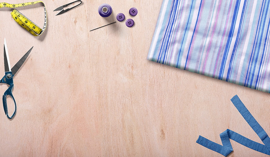 Sewing Supplies Flat Lay on Wooden Table with Scissors and Fabric