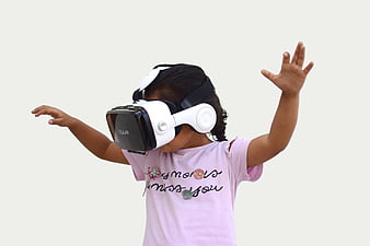Child Wearing VR Headset Reaching Out Against White Background