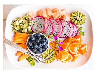 Overhead view of colorful fruit platter with dragon fruit, kiwi, and oranges
