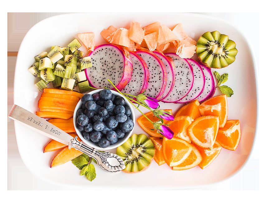 Overhead view of colorful fruit platter with dragon fruit, kiwi, and oranges