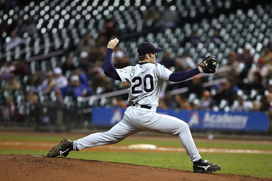 Baseball Pitcher in Action on Mound at Night