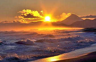 Dramatic Golden Sunset Over Ocean Waves And Distant Volcanic Mountain