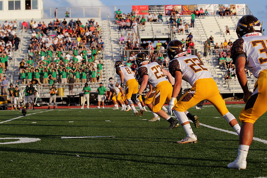 American Football Team Lineup on Field with Crowd