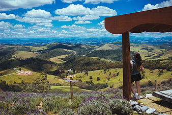 Woman Looking at Scenic Rolling Hills and Blue Sky