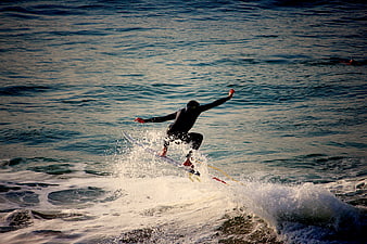 Surfer in Wetsuit Riding Wave with Splash