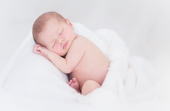 Sleeping newborn baby wrapped in white blanket