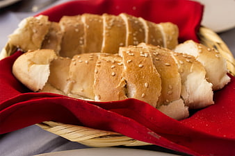 Fresh Sesame Bread Rolls in Wicker Basket with Red Napkin