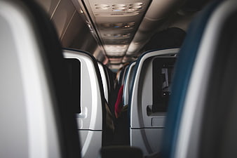 View down airplane aisle with blurred seats and passengers