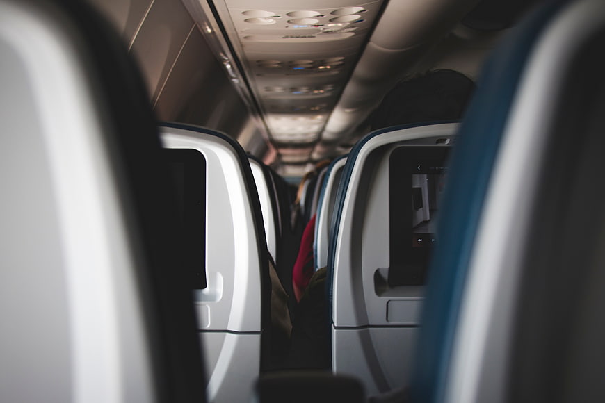 View down airplane aisle with blurred seats and passengers