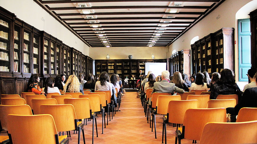 Audience attending a lecture in a historic library hall