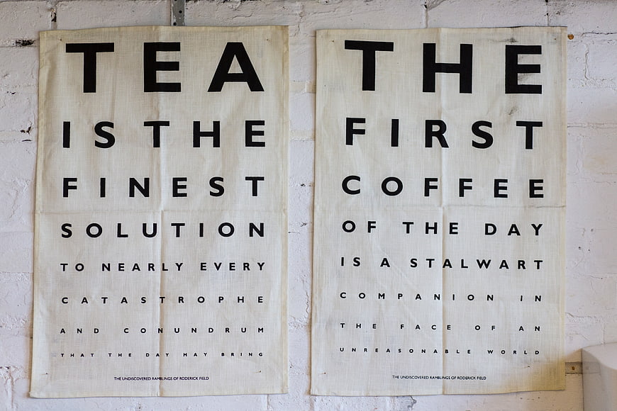 Vintage Typography Posters Featuring Tea and Coffee Quotes on White Brick Wall