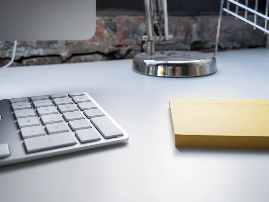 Minimalist Office Desk with Keyboard and Yellow Notepad