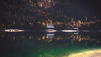 Serene Alpine Lake with Autumn Reflections and Mountain Lodge