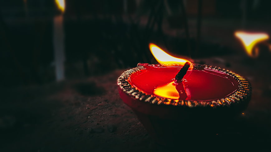 Traditional red clay diya oil lamp with flame