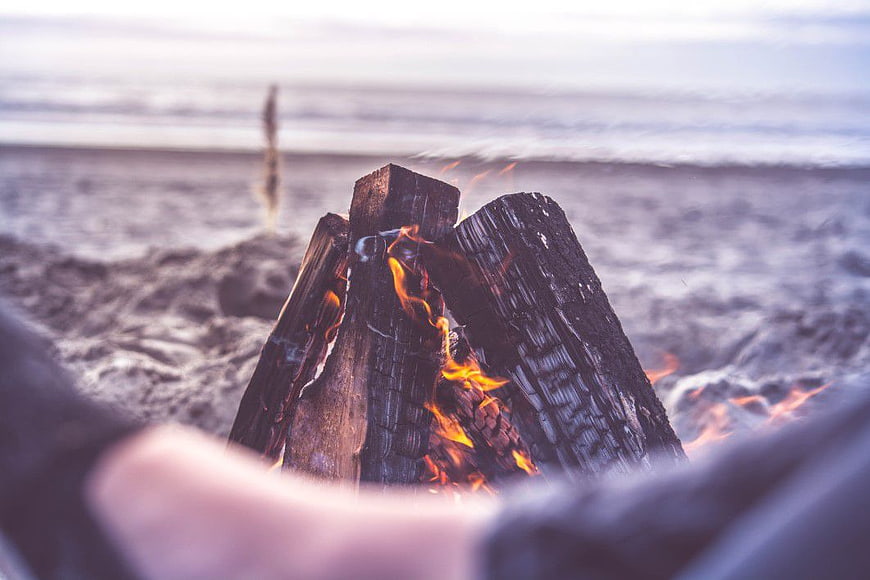 Close-up of Beach Bonfire with Blurred Ocean Background