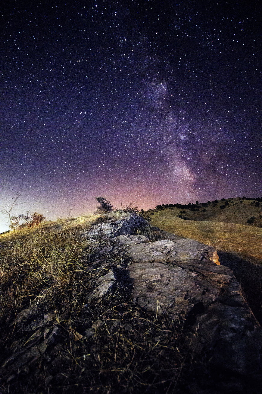 Milky Way Galaxy Over Rocky Hillside at Night