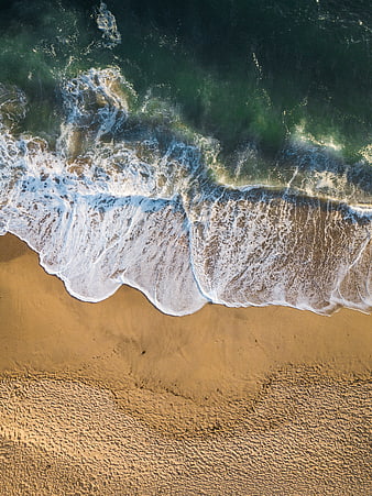 Aerial View of Ocean Waves Crashing on Sandy Beach
