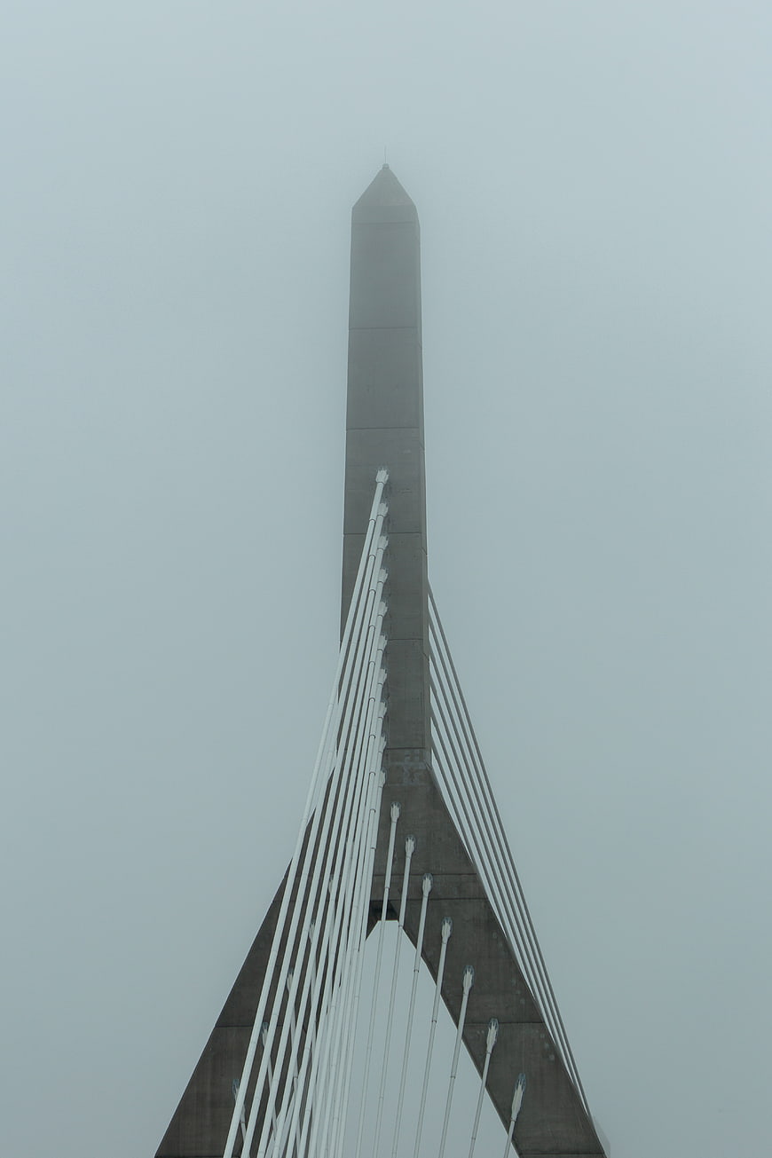 Modern cable-stayed bridge tower in thick fog
