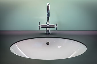 Modern chrome faucet on dark vanity with white sink