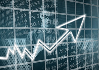 Young businessman with glasses analyzing financial growth chart