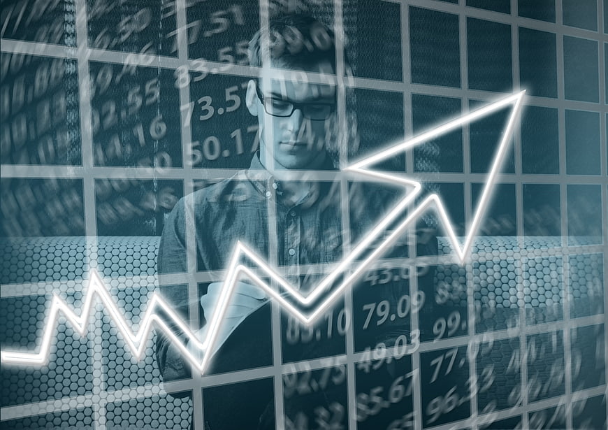 Young businessman with glasses analyzing financial growth chart