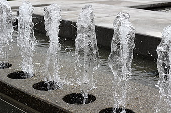 Close-up of water jets spraying from a modern outdoor fountain