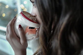 Woman drinking from cute mug with bokeh background