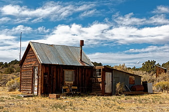 Rustic wooden cabin in arid landscape with blue sky