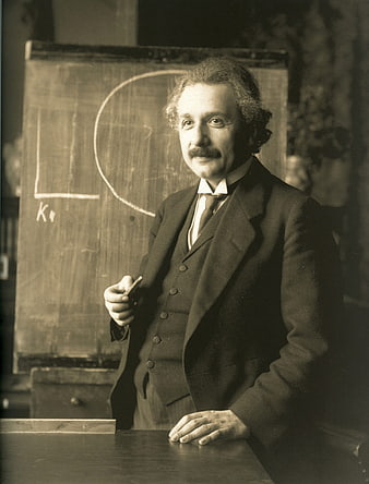 Historical Black and White Portrait of Albert Einstein Standing at Blackboard