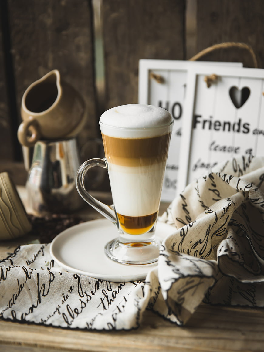Layered coffee latte in glass with rustic decor