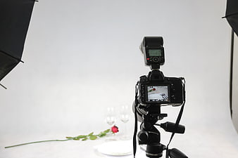 DSLR Camera on Tripod in Studio with Rose and Wine Glasses