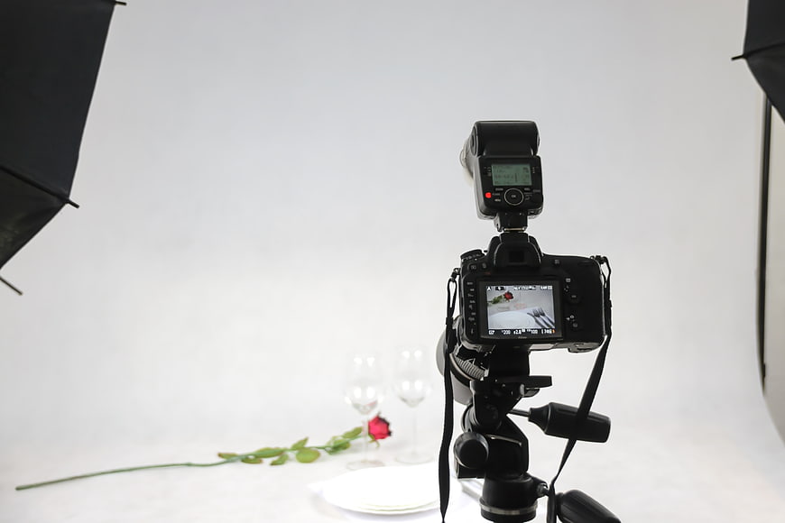 DSLR Camera on Tripod in Studio with Rose and Wine Glasses